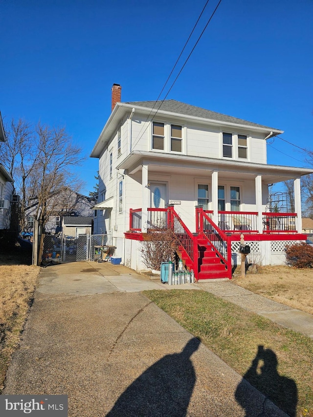 traditional style home with covered porch and a chimney