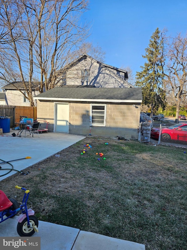 view of side of property with a patio and a lawn