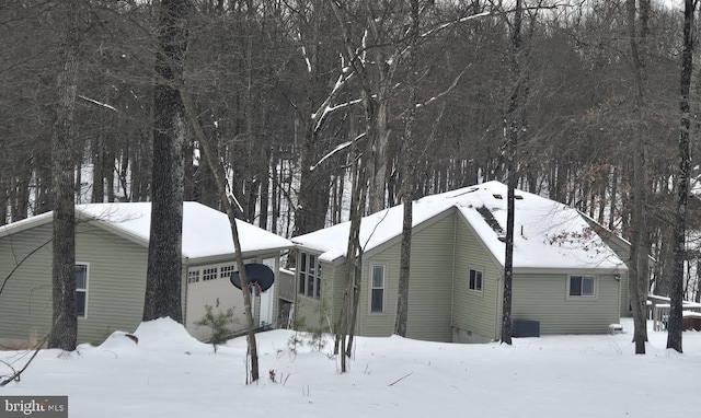 snow covered property featuring central AC unit