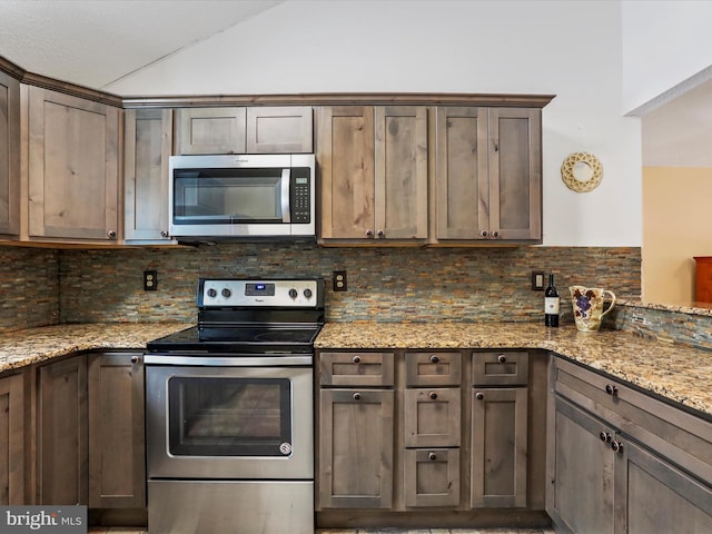 kitchen featuring light stone countertops, appliances with stainless steel finishes, and backsplash