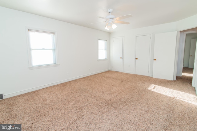 unfurnished bedroom with multiple windows, ceiling fan, and carpet