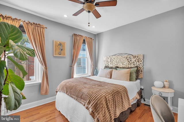 bedroom featuring multiple windows, ceiling fan, and light wood-type flooring