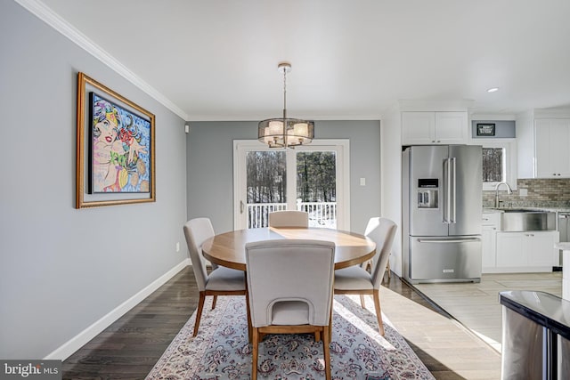 dining space featuring light hardwood / wood-style flooring, an inviting chandelier, and crown molding