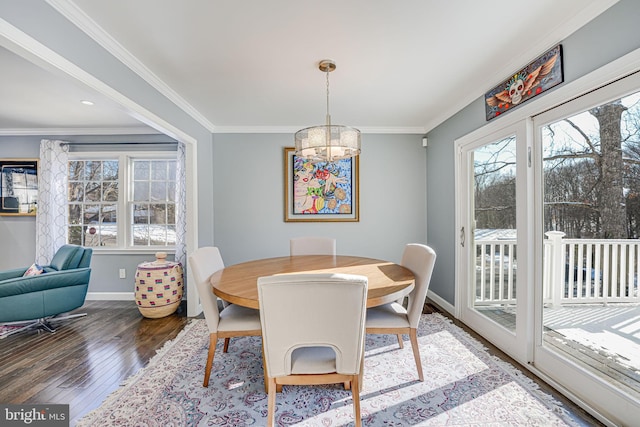 dining area with ornamental molding, an inviting chandelier, and dark hardwood / wood-style flooring