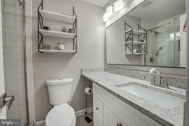 bathroom featuring tile patterned flooring, toilet, walk in shower, and vanity