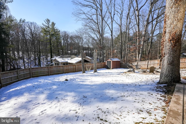 snowy yard featuring a fire pit and a shed