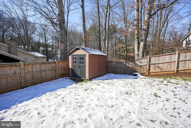 yard layered in snow featuring a storage shed