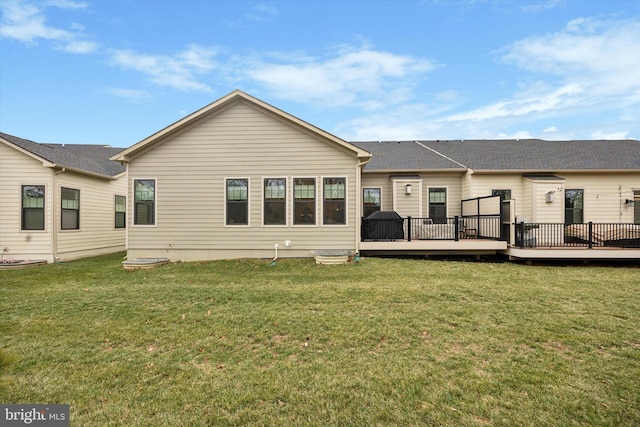 back of property with a lawn and a deck