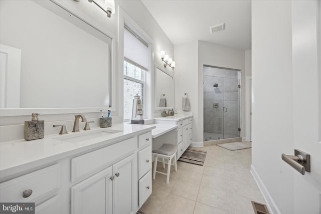 bathroom featuring tile patterned flooring, vanity, and a shower with door