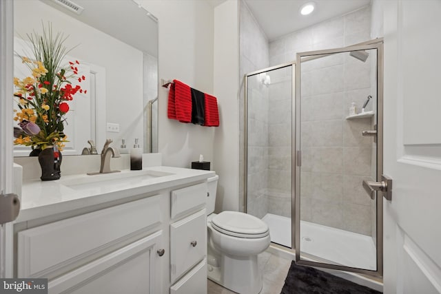 bathroom featuring toilet, vanity, tile patterned floors, and a shower with door