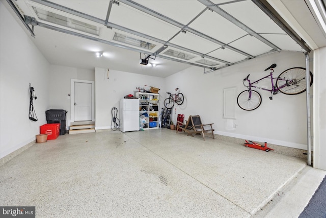 garage with white fridge and a garage door opener