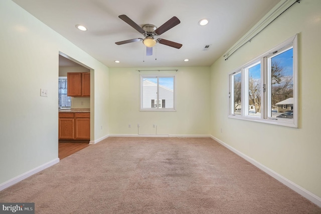 carpeted spare room featuring ceiling fan