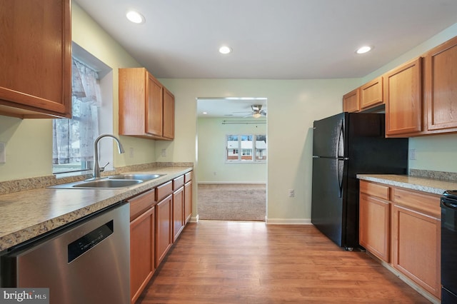 kitchen featuring ceiling fan, sink, black fridge, stainless steel dishwasher, and light wood-type flooring