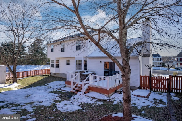 snow covered house featuring a deck