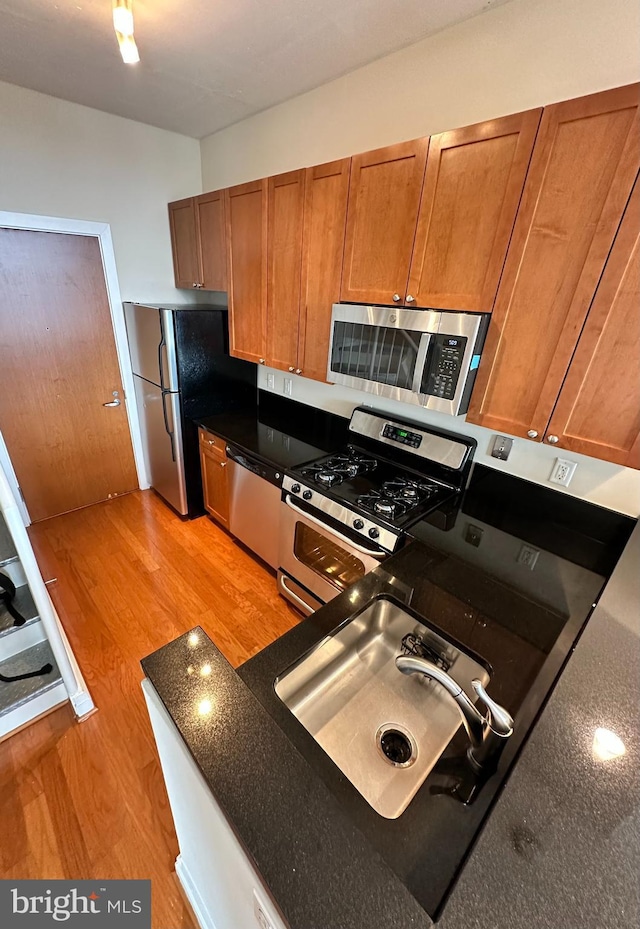 kitchen featuring light wood-type flooring, stainless steel appliances, and sink