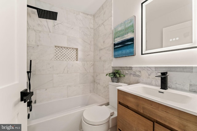 full bathroom with vanity, toilet, tiled shower / bath, and tile walls