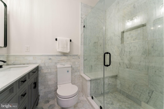 bathroom featuring vanity, tile walls, tile patterned flooring, toilet, and a shower with shower door