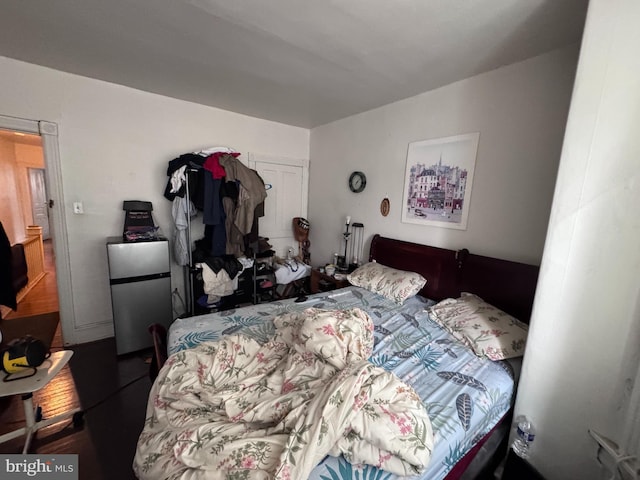 bedroom with stainless steel refrigerator and a closet