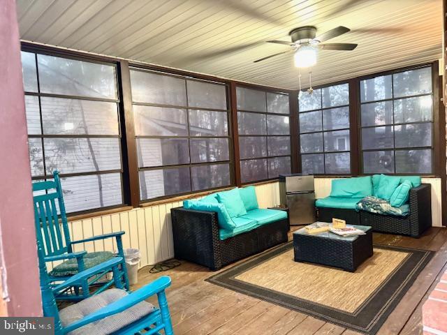 sunroom / solarium featuring ceiling fan