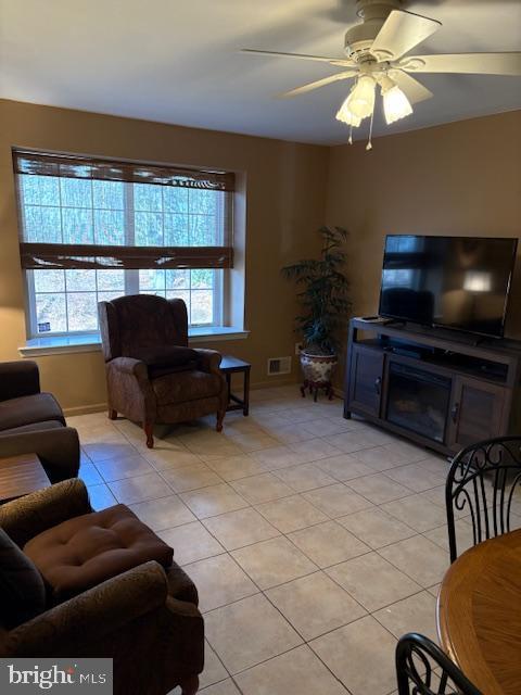 living room with visible vents, a ceiling fan, and light tile patterned flooring