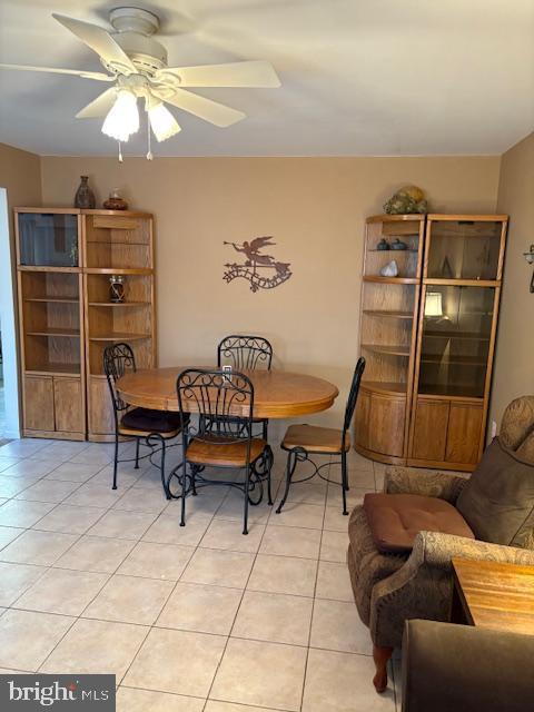 dining space with a ceiling fan and light tile patterned floors