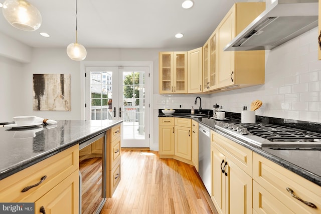 kitchen featuring appliances with stainless steel finishes, beverage cooler, sink, exhaust hood, and decorative light fixtures