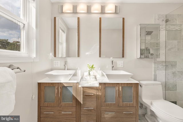 bathroom featuring vanity, toilet, and a tile shower