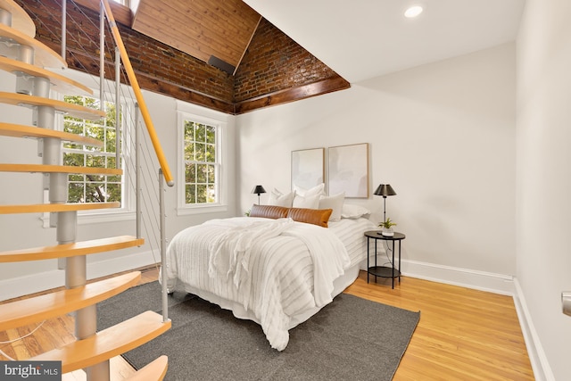 bedroom featuring hardwood / wood-style flooring and high vaulted ceiling