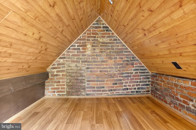 additional living space featuring brick wall, wooden ceiling, lofted ceiling, and light hardwood / wood-style floors