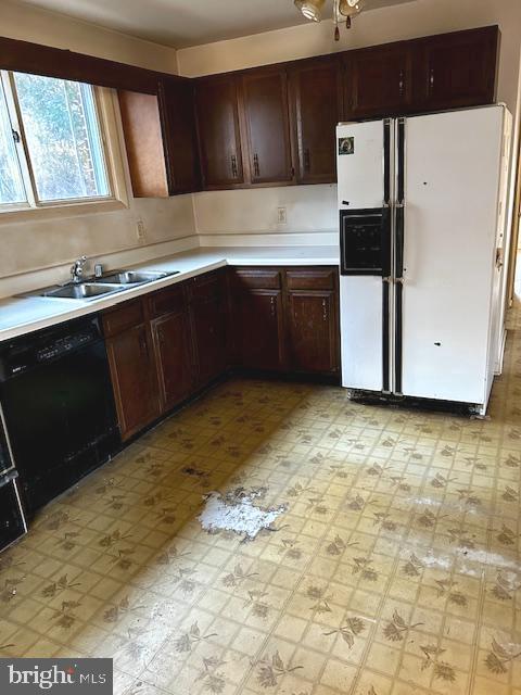 kitchen with dark brown cabinets, sink, white refrigerator with ice dispenser, and black dishwasher