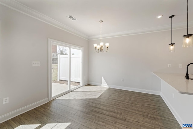 unfurnished dining area with hardwood / wood-style flooring, a notable chandelier, and ornamental molding