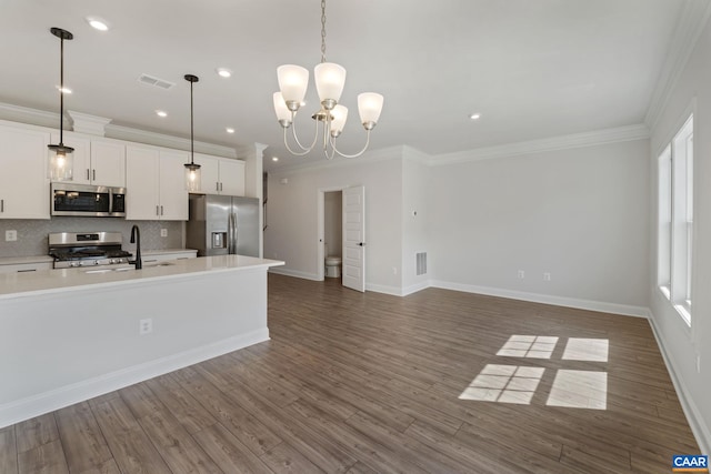 kitchen with white cabinets, pendant lighting, stainless steel appliances, and a chandelier