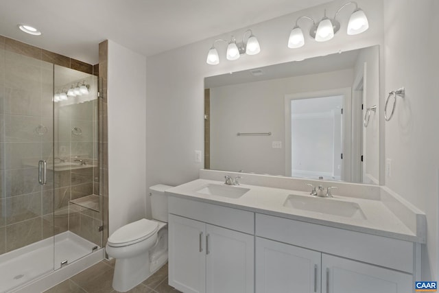 bathroom with tile patterned flooring, vanity, a shower with door, and toilet