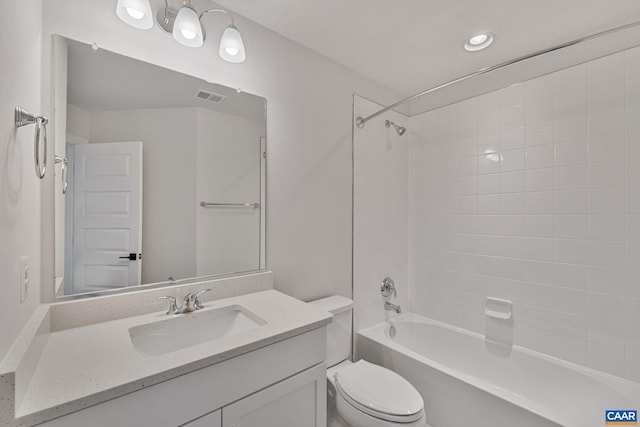 full bathroom featuring vanity, tiled shower / bath combo, and toilet