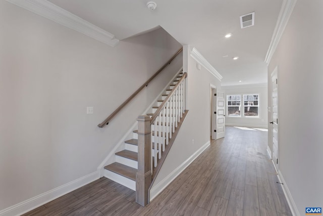 stairs with wood-type flooring and crown molding