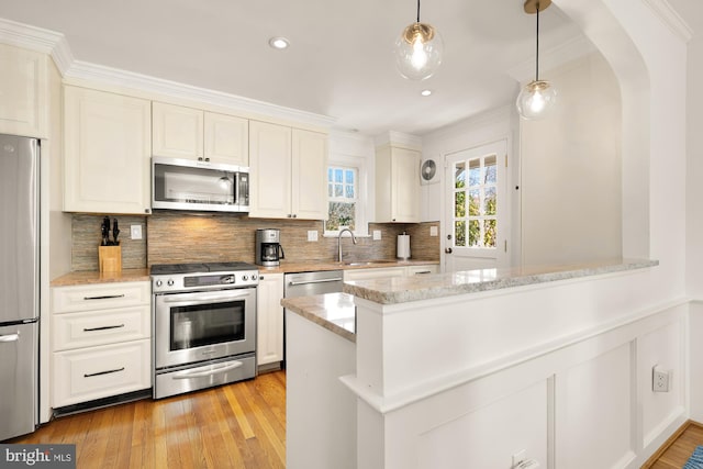 kitchen featuring white cabinetry, arched walkways, appliances with stainless steel finishes, a peninsula, and decorative backsplash