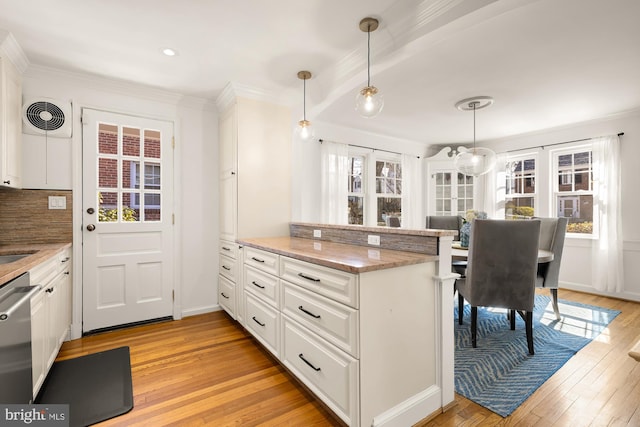 kitchen featuring visible vents, light wood finished floors, white cabinetry, a peninsula, and stainless steel dishwasher