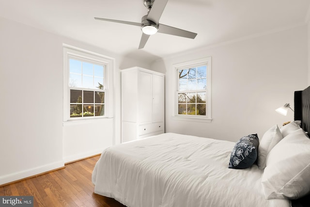 bedroom featuring a closet, a ceiling fan, baseboards, and wood-type flooring