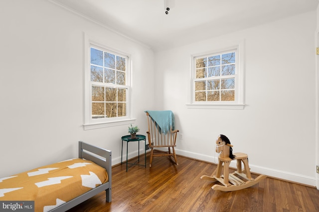 living area featuring crown molding, plenty of natural light, wood finished floors, and baseboards