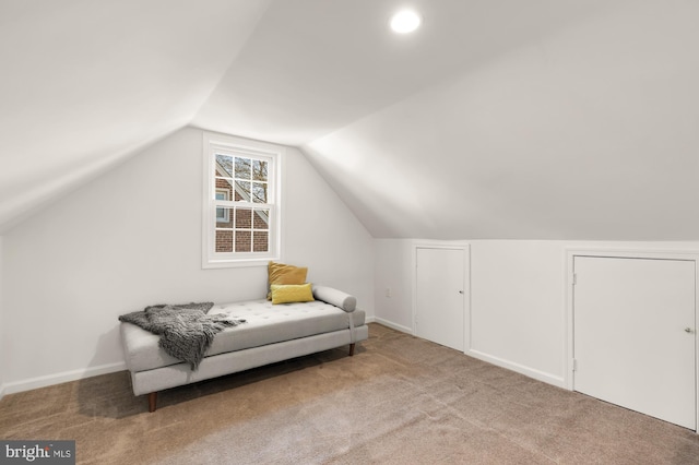 living area featuring baseboards, carpet flooring, and vaulted ceiling