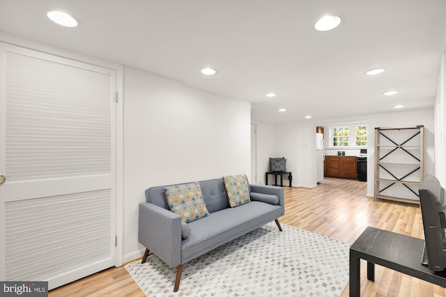 living room featuring light wood-style flooring, recessed lighting, and baseboards