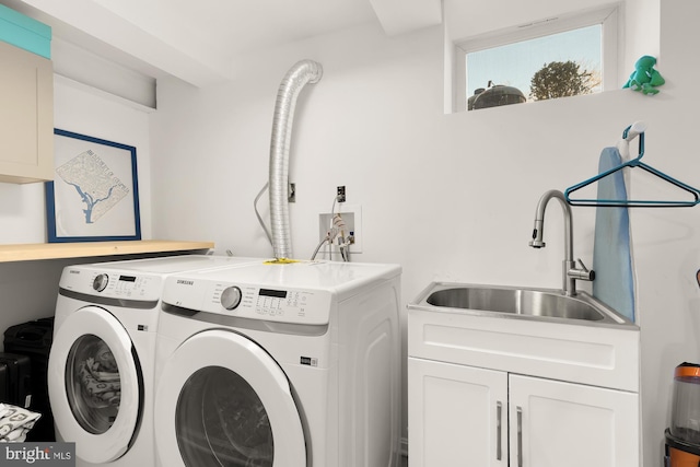 washroom with washer and dryer, cabinet space, and a sink