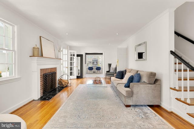 living area with stairway, plenty of natural light, and wood finished floors