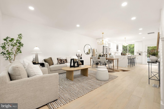 living room featuring light hardwood / wood-style flooring and a chandelier