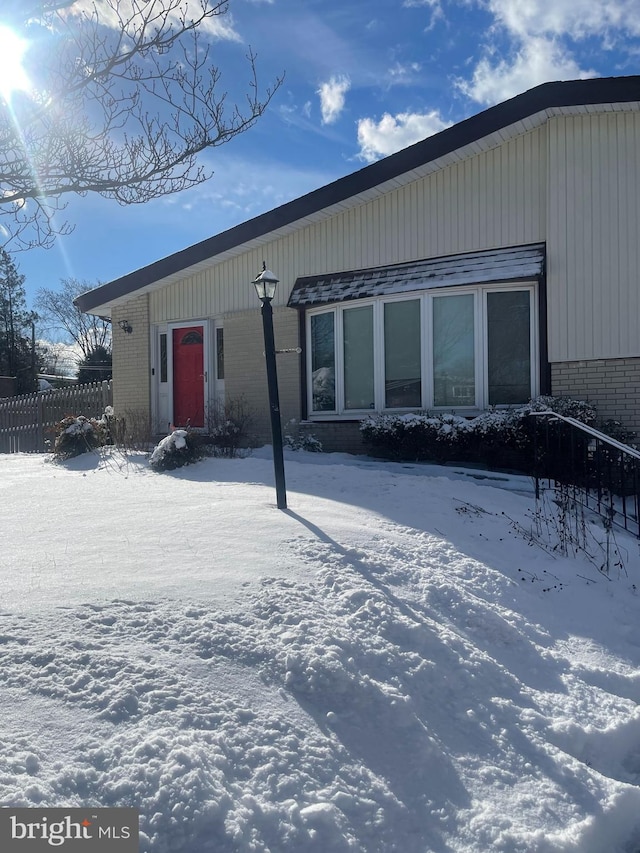 view of snow covered rear of property