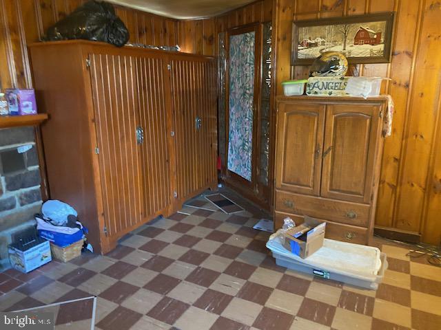 interior space with tile patterned floors and wood walls