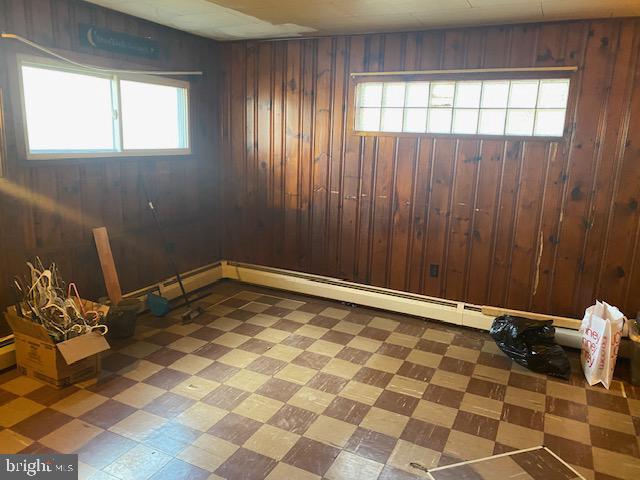 below grade area featuring tile patterned floors and wood walls