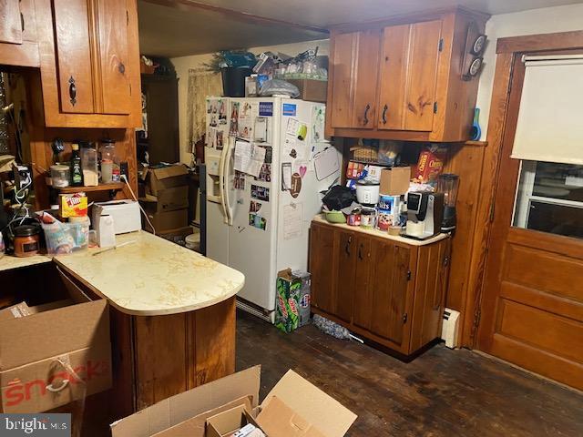 kitchen featuring dark hardwood / wood-style flooring and white fridge with ice dispenser