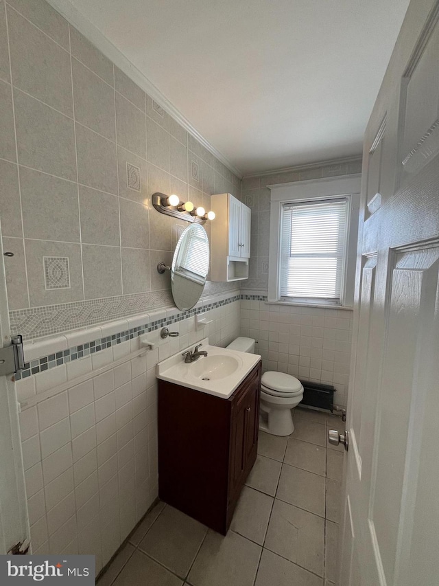 bathroom featuring tile patterned flooring, vanity, tile walls, and crown molding