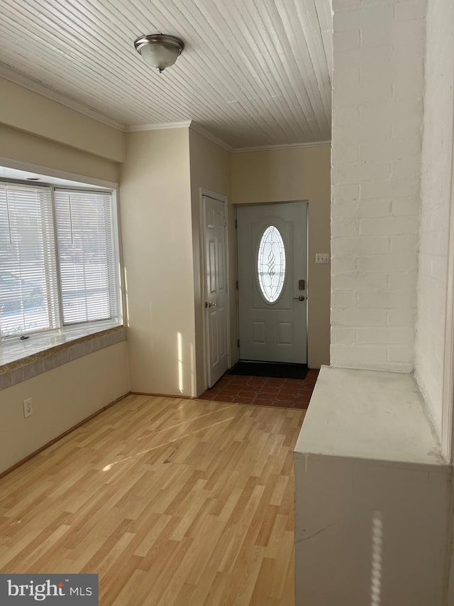 foyer entrance with wooden ceiling, plenty of natural light, wood-type flooring, and ornamental molding